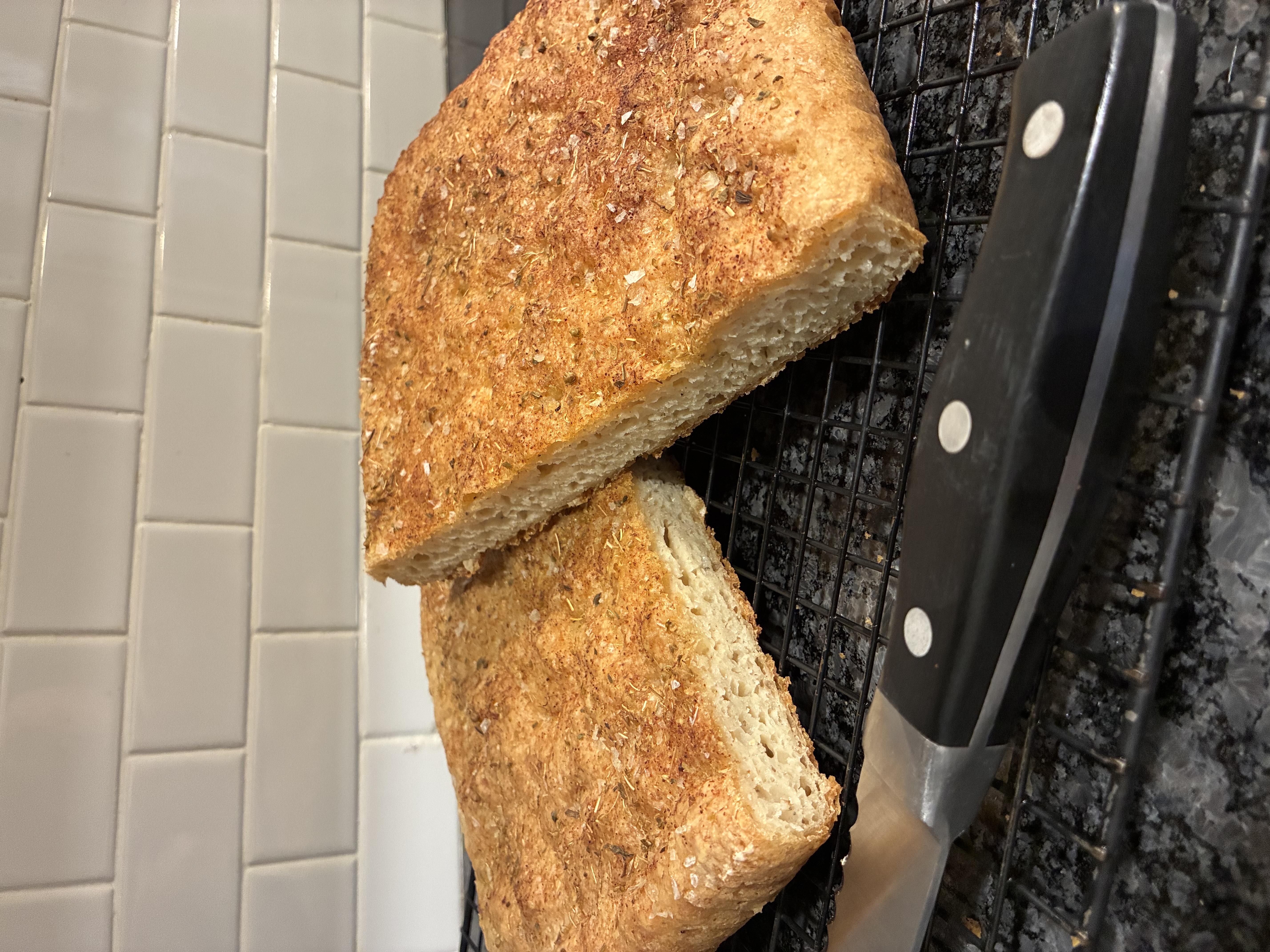Sliced focaccia bread with herbs and flaky salt